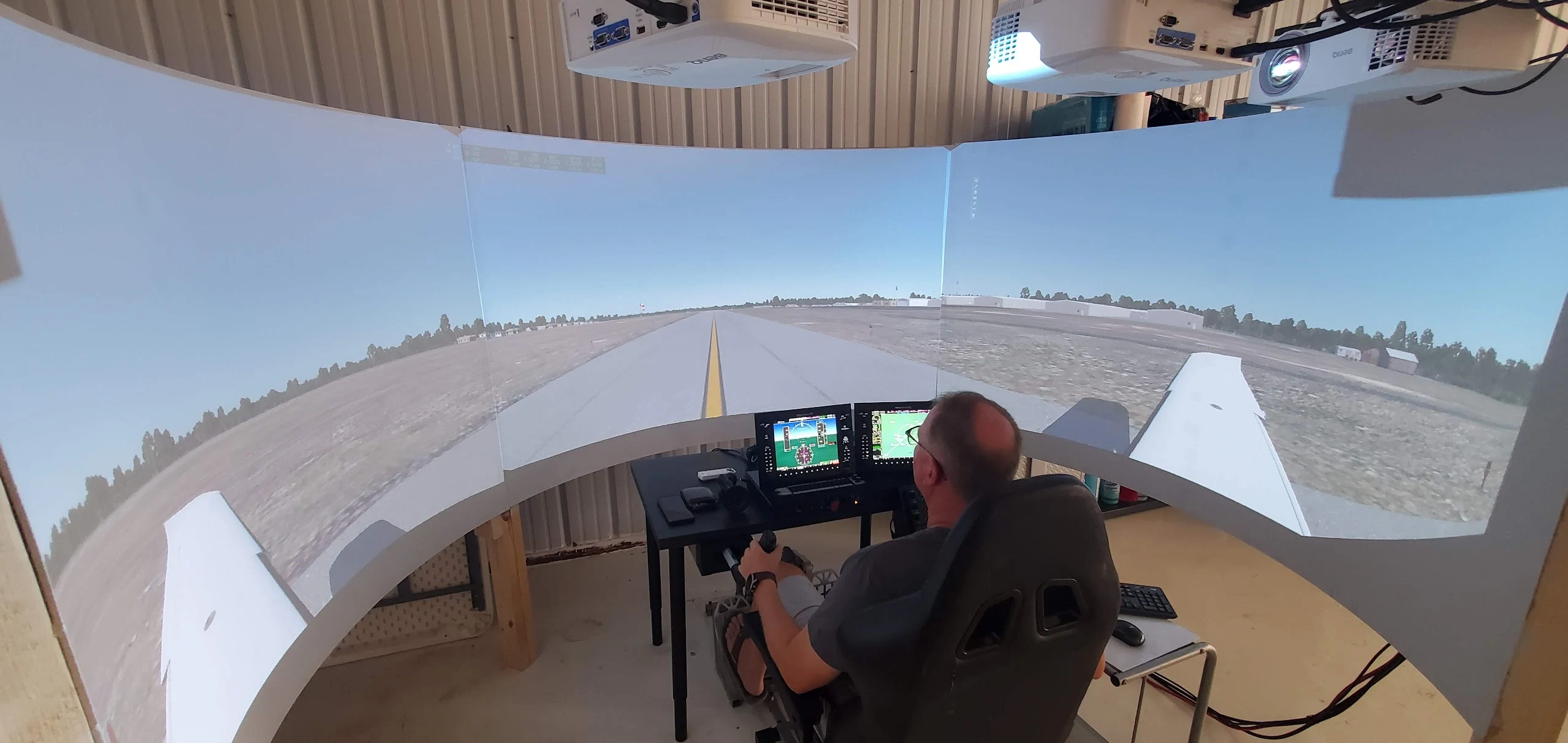 Pilot using a physical cockpit with a curved projection display